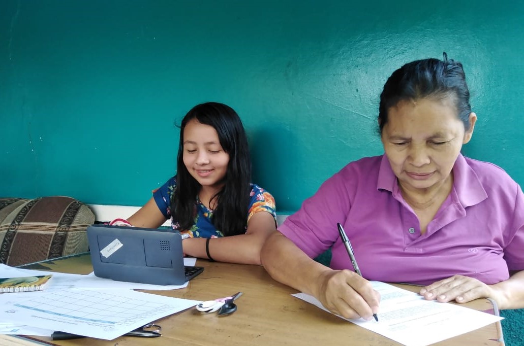 Laura, a 7th grader, and her grandmother picking up a tablet so she can study from home.